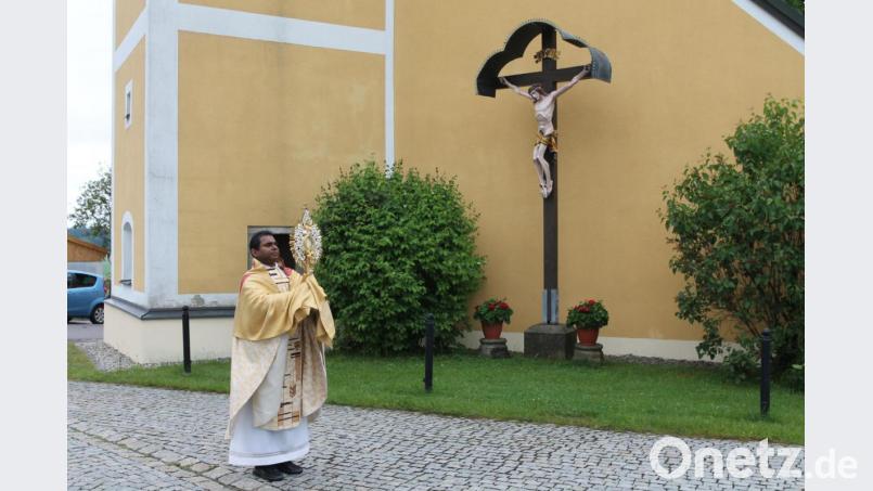 Pfarrer Julius Johnrose segnet vor der Pfarrkirche Neukirchen zu St. Christoph den Ort in alle Himmelsrichtungen. Bild: pi