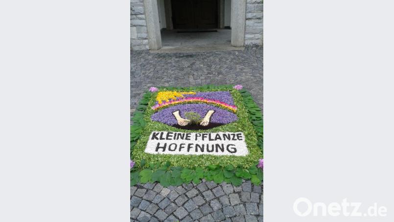 Zum Fronleichnamsfest hatte das Familiengottesdienst-Team vor der Pfarrkirche Patrona Bavariae einen Blumenteppich unter dem Motto „Kleine Pflanze Hoffnung“ gelegt. Bild: öt