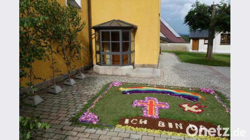 Auf dem Vorplatz der Pfarrkirche erinnert ein Blumenteppich an den Feiertag Fronleichnam. Bild: fjo