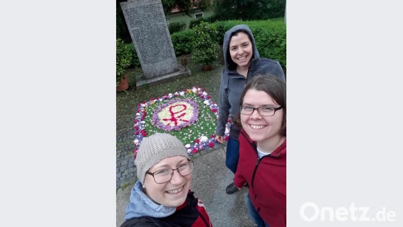 Während einige KLJB-Mitglieder Blumen sammeln und anliefern, legen Lena Schulze, Anna und Luzia Wittmann (von links) den Blumenteppich für das Fronleichnamsfest am Kriegerdenkmal im Vorhof der Pfarrkirche St. Matthäus in Wurz. Bild: szl