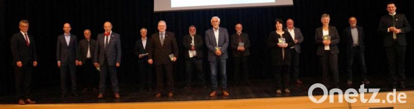 Landrat Thomas Ebeling (rechts) und der Kreisvorsitzende Martin Birner (links) bedankten sich bei den dreizehn ausscheidenden Bürgermeistern und Bürgermeisterinnen für ihre engagierte Arbeit und überreichten ein kleines Präsent. Bild: weu