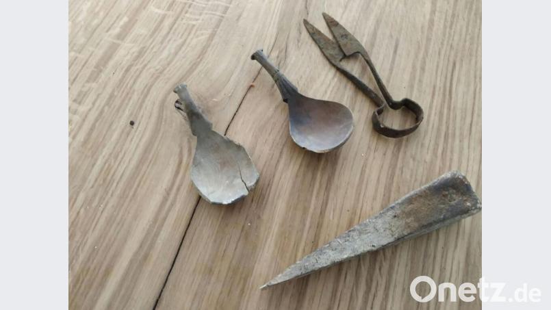 Zwei Esslöffel aus Holz, von denen einer kunstvoll verziert ist, eine eiserne Bügelschere und ein Spaltkeil aus Eisen: Diese mittelalterlichen Alltagsgegenstände gaben die Fehlböden des Hauses Schiffgasse 3 bei der Sanierung frei. Bild: Kerstin Weiß/Stadt Amberg