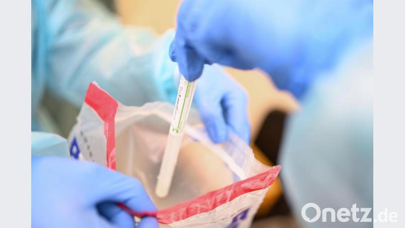 Eine Ärztin gibt einen Abstrichstäbchen im Plastikröhrchen in einen Plastikbeutel, nachdem sie einem Patienten einen Abstrich aus dem Rachen entnommen hat. Bild: Felix Kästle/dpa