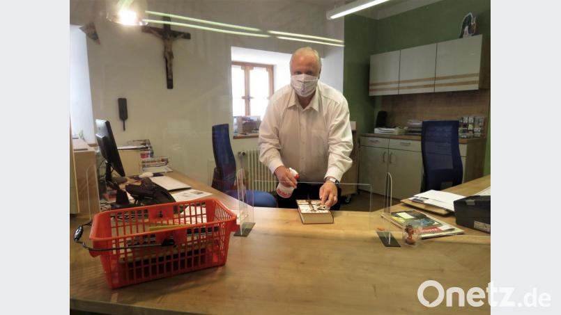 Gerhard Laab desinfiziert seine Bücher in der Stadtbücherei Waldsassen mit Mundschutz und Handschuhe hinter einer Plexiglasscheibe, die neu installiert wurde. Mehr Schutz vor Ansteckung mit dem Virus ist kaum möglich. Bild: ubb