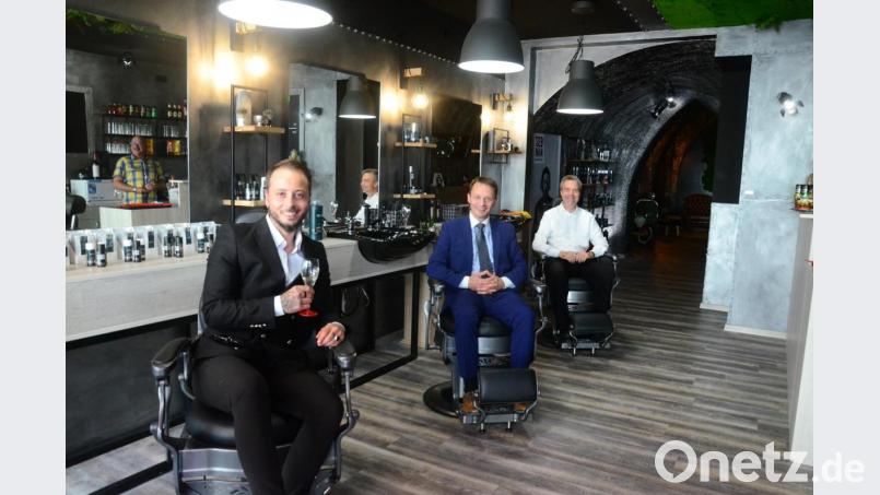 In einem künstlerischen Ambiente will Emilio Bruner (links) ab sofort seinen männlichen Kunden die Haare schneiden. Zur Eröffnung gratulieren Oberbürgermeister Jens Meyer (Mitte) und Stadtpfarrer Markus Schmid. Bild: Kunz