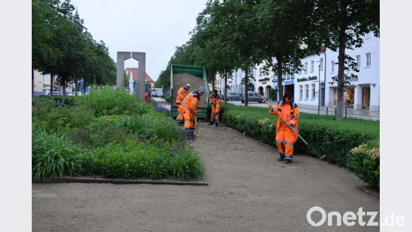Die Bauhofmitarbeiter tragen den neuen Kies auf dem Gehweg in den Grünanlagen des Maximilianplatzes auf. Ende Juni ist der Untere Marktplatz dann wieder für Fußgänger geöffnet. Bild: szl