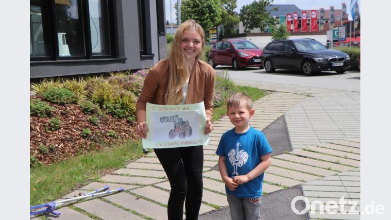 Corinna Gleißner erhält als Dankeschön für das Zusammenbauen der Traktoren von Gregor ein selbst ausgemaltes Traktor-Bild. Bild: vlu