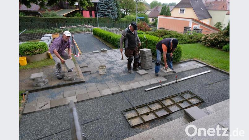 Fleißig Hand legt Steinmetzmeister Franz Schmidt mit seinen Helfern Oskar Lang und Robert Säckl bei den Sanierungsarbeiten am Treppenaufgang und bei Verlegung von 60 Quadratmetern neuer Gehwegplatten am Hauptzugang zur Pfarrkirche St. Johannes der Täufer an. Bild: le