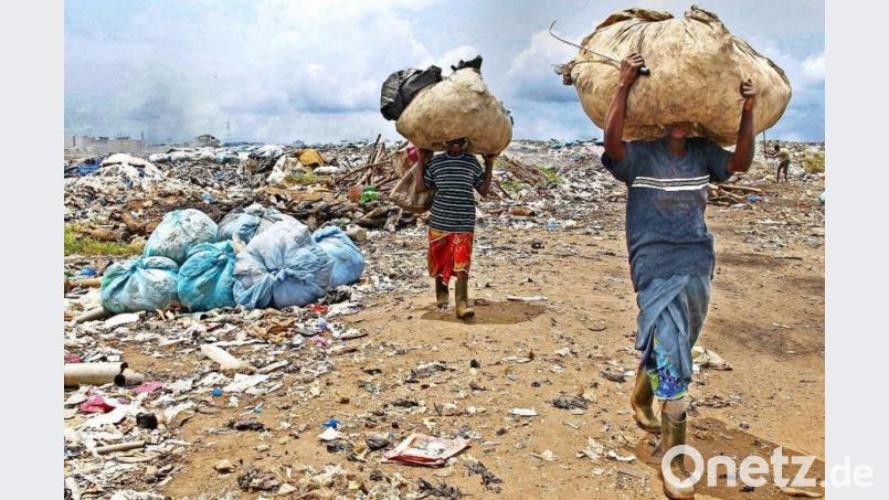 Ein Bild der Armut von der Elfenbeinküste: Frauen tragen in Abidjan recyclingfähige Materialien, die sie auf einer Deponie gesammelt haben. Bild: agentur_dpa