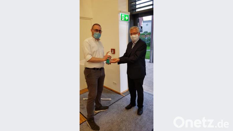 BRK Bereitschaftsleiter Sven Lehner (links) gibt Desinfektionsmittel auf Bürgermeister Johannes Regers (rechts) Hände. Der Rathauschef war einer von insgesamt 262 Spendern, darunter 30 Erstspender. Bild: fks