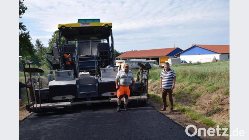 Nach den vergangenen Regentagen sind die Teerarbeiten in der Hammerbergstraße sehr zügig abgelaufen. Bürgermeister Peter Braun (rechts) begutachtet mit Polier Wolfgang Schollerer (links) von der Firma Stragbag aus Schwandorf das Ergebnis. Bild: bö