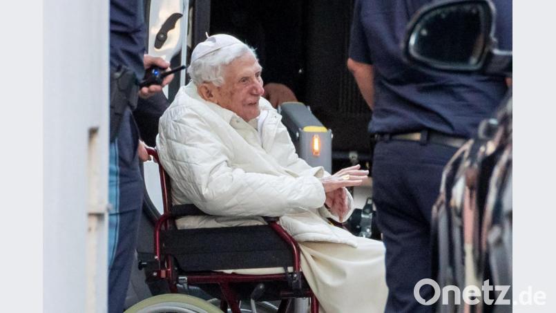 Der emeritierte Papst Benedikt XVI wird in Regensburg mit einem Rollstuhl in einen Bus geschoben. Archivbild: Daniel Karmann