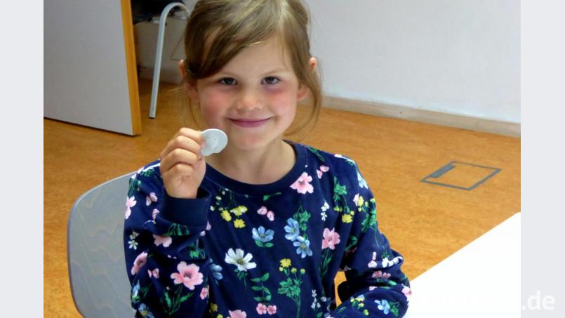 Emi hält stolz ihren selbst gemachten Fossilstein in Händen. Bild: fsb