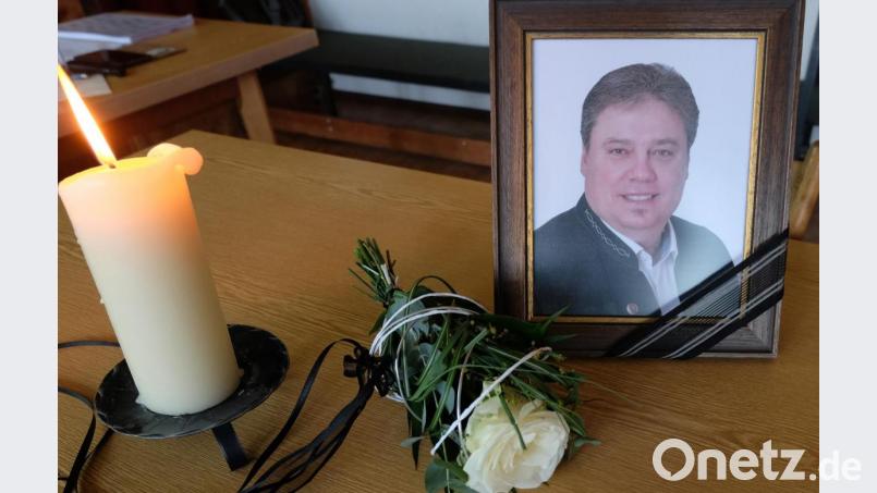 Sein Platz am Ratstisch blieb frei. Das Bild, die brennende Kerze und eine weiße Rose erinnerten an Hans Gradl und ließen ihn präsent sein. Bild: ohr