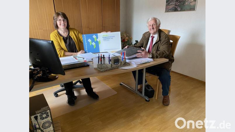 Marika Mauerer und Fred Lehner, nicht verwandt, nicht verschwägert, aber wie Tochter und Vater der Baugenossenschaft „Eigenheim“; der Verband bayerischer Wohnungsunternehmen steuert zum Hundertjährigen ein Schild für das Bürogebäude bei. Bild: Eichl
