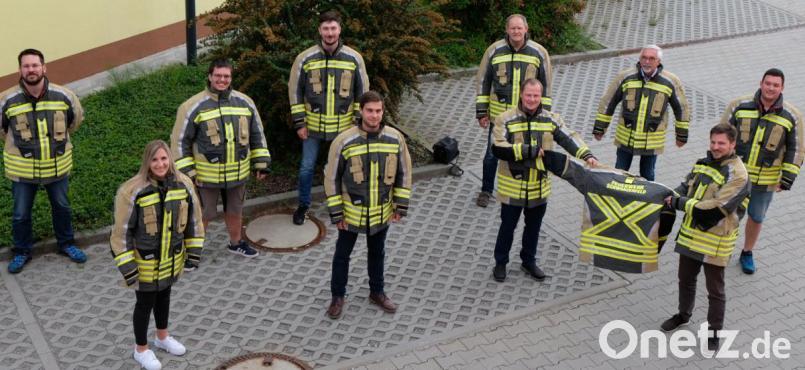 Zusammen mit den Verantwortlichen der vier Ortsfeuerwehren präsentieren die zuständige Mitarbeiterin im Rathaus für Feuerwehraufgaben, Teresa Scholz, sowie Bürgermeister Peter Neumeier (vorne rechts) mit seinem Vorgänger Manfred Rodde (dahinter) die neuen Schutzanzüge. Bild: mab
