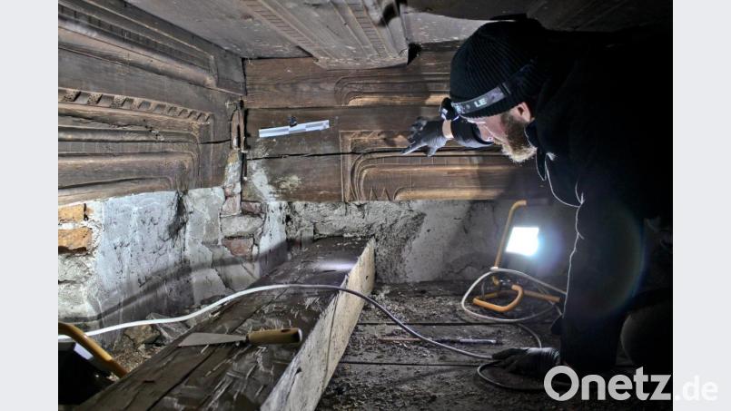 Im Licht von Scheinwerfer und Stirnlampe begutachtet Bauherr Johannes Steidl die entdeckten Schnitzereien. Der Architekt ist ganz begeistert davon, wie gut sich die Schiffskehlen, Bänderungen und Ornamente über die Jahrhunderte hinweg erhalten haben. Bild: Johannes Steidl
