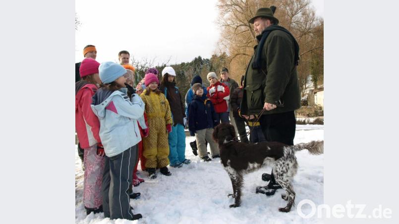 Jäger Ludwig von Stern und seine Jagdhündin Cilla führen Kinder durch den Winterwald. Bild: ntz