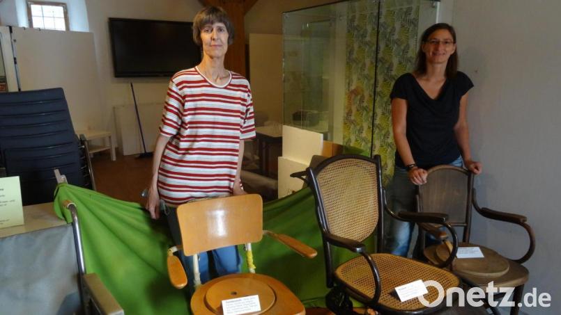Edith Zimmermann (links) und Iris Kaiser mit ihren interessanten Fundstücken. Der Toilettenstuhl (rechts) und der Rollstuhl daneben stammen aus der Zeit um 1900. Bild: hka