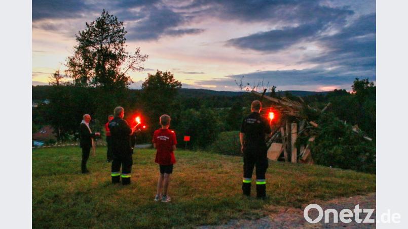 Pfarrer Herbert Rösl (links) segnete das Feuer zusammen mit den Feuerwehrleuten der Brandwache. Sowohl der Gottesdienst als auch der Festbetrieb wurden heuer abgesagt. Bild: tkr