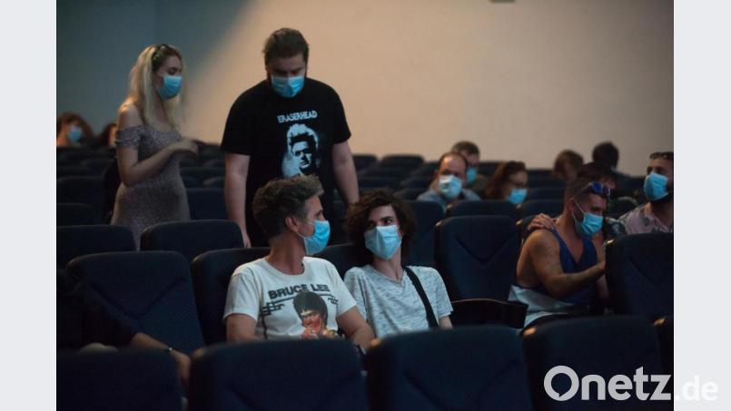 Zuschauer mit Mundschutzmasken sitzen in einem Kinosaal. Ab 1. Juli sollen Kulturveranstaltungen in Bayern auch ohne Maske möglich sein. Bild: Jesus Merida/dpa