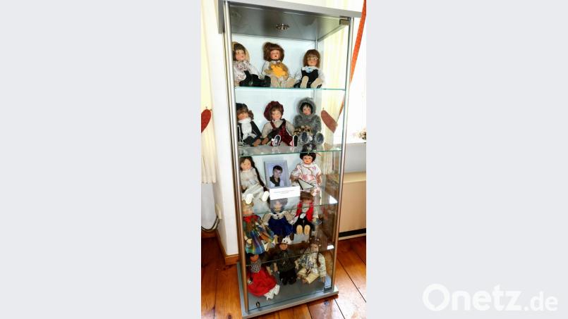 14 der 28 kleinen Kunstwerke von Gertrud Dobmeier sind mit dem Bild der Künstlerin in der Glasvitrine im Vorraum des Trauungszimmers zu sehen. Bild: le