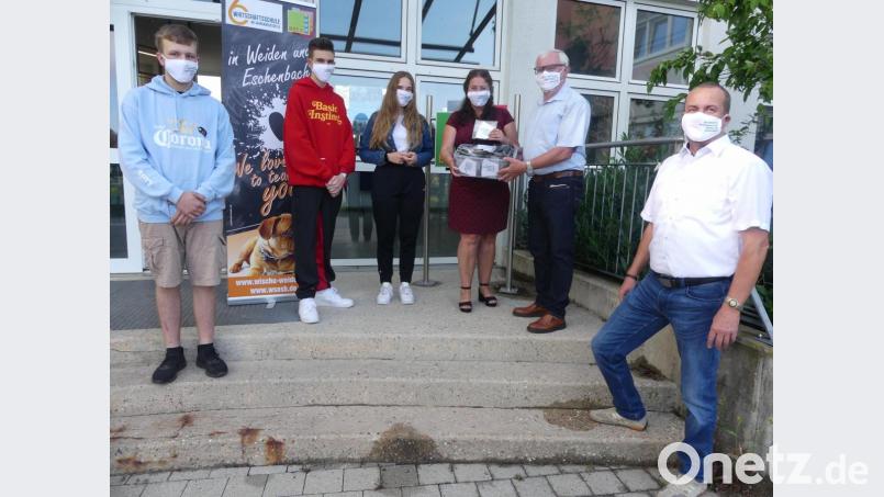 Im Beisein von stellvertretendem Schulleiter Bernhard Miedl übergaben Walter Schnoy und Annegret Kennel an die Absolventen Annalena Walter (10c), Andre Andrigo und Luis Lottes (beide 10d) Mund- und Nasenmasken mit dem Schriftzug ihrer Schule. Bild: rn