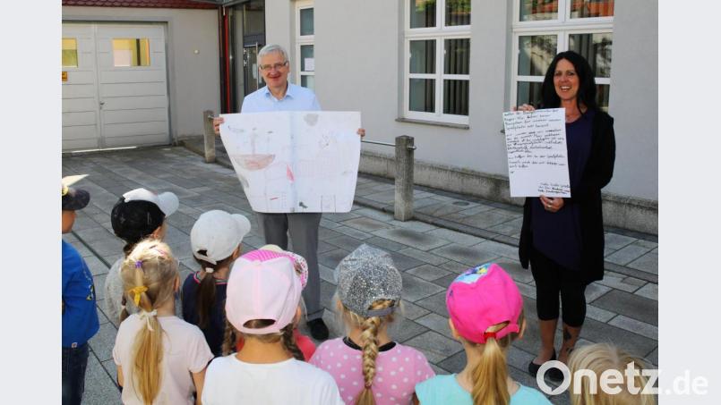 Die Buben und Mädchen des St.-Elisabeth-Kindergartens überreichten ihren Spielplatzbauplan an Bürgermeister Johannes Reger (links). Mit auf dem Bild ist Erzieherin Tanja Heider. Bild: JOCHEN NEUMANN 
ERBENDORF