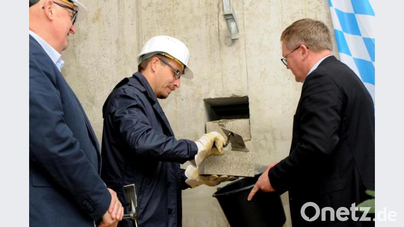 Feierliche Grundsteinlegung zu der seit 2012 laufenden Grundsteinlegung der Franz-Xaver-von-Schönwerth-Realschule an der Fuggerstraße: Schulleiter Matthias Schall mauert, OB Michael Cerny hält den Mörtel-Eimer und Architekt Alfred Lanzinger steht für den symbolischen Hammerschlag bereit. Bild: Stephan Huber