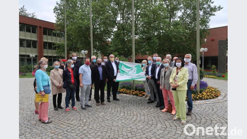 Politiker und Vertreter von Bürgerinitiativen hissen die Fahne zum &quot;Flaggentag der Bürgermeister&quot;. Bild: Kunz
