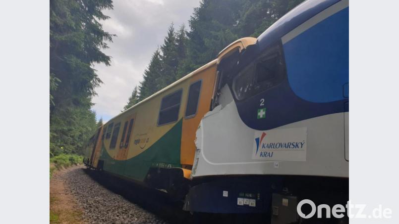 Zwei Züge stehen nach einer Kollision ineinander verkeilt auf einem Gleis. Beim Frontalzusammenstoß zweier Personenzüge auf einer Strecke durch das Erzgebirge zwischen Tschechien und Deutschland hat es Tote und Verletzte gegeben. Bild: Czech Republic Police/AP/dpa
