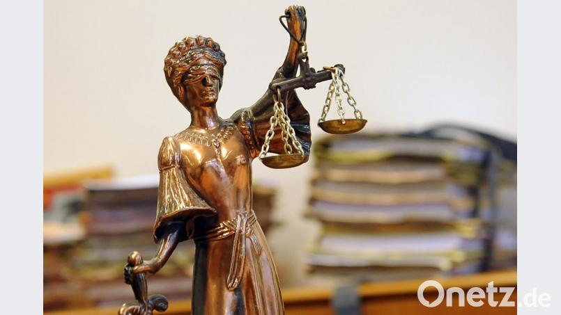 Eine goldfarbene Justitia-Figur steht vor Aktenbergen. Symbolbild: Britta Pedersen