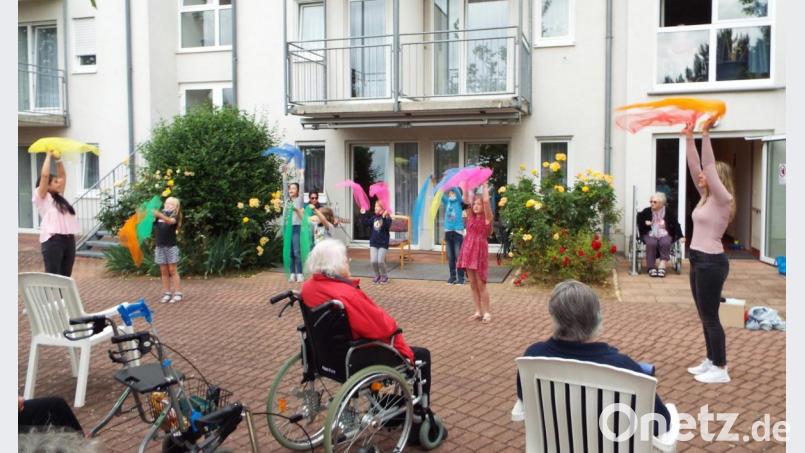 Bunte Tücher werden geschwenkt bei der Abschlussveranstaltung zum Seniorenprojekt im Kümmersbrucker AWO-Heim. Bild: e