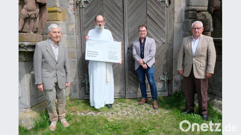 Vor dem Portal der Barbaraberg-Kapelle überreichen Stiftungsvorsitzender Georg Girisch (von rechts) sowie die Vorstandsmitglieder Michael Menner und Ludwig König (von links) an Pater Benedikt Schuster den symbolischen Spendenscheck. Bild: do