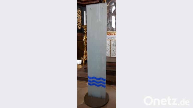 An den Drahtseilen der auf einem Metallsockel stehenden Glasstele sollen die Bilder der Täuflinge mithilfe von kleinen Magneten angebracht werden. Bild: hmr