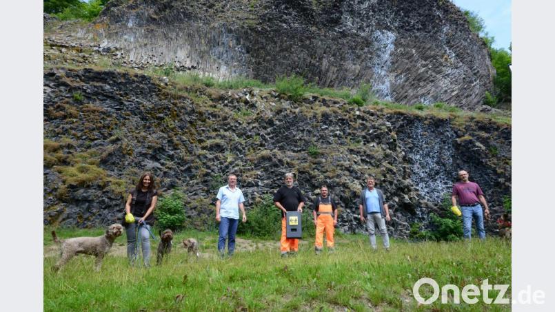 Nicole Holtmeier (links) und Wolfgang Schreffl (rechts) haben die leuchtend gelbe Tüte für das Einsammeln des Hundekots schon mal in die Hand genommen. Bauhofleiter Erwin Glaubitz hat den Spender in der Hand, der dort an der vor der Basaltwand vor der öffentlichen Toilette angebracht wird. Bürgermeister Reinhard Sollfrank (Zweiter von rechts) ist zuversichtlich, dass das Angebot des Marktes ein Beitrag zum Schutz der Umwelt beträgt. Bild: bey