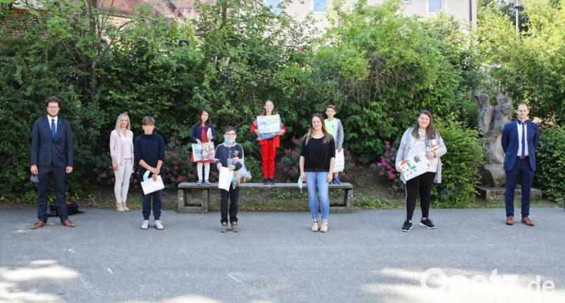 Geschäftsstellenleiter Alexander Goblirsch (links) und Bankmitarbeiter Viktor Hofmann (rechts) überreichten im Beisein von Rektorin Sabine Graser (Zweite von links) die Preise an die besten Künstler der Schule. Bild: njn