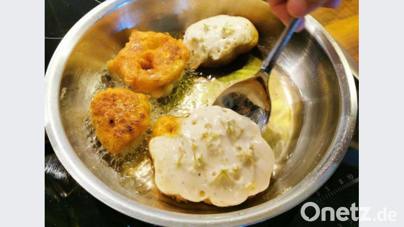 Die Hollerküchel werden im heißen Fett herausgebacken. Nachdem der Stiel abgeschnitten wurde, werden sie gewendet. Köstlich schmeckt dazu ein säuerliches Mus oder Kompott. Bild: Heike Heindl/exb