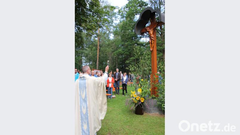 Stadtpfarrer Dr. Thomas Vogl segnete das mit viel Liebe zum Detail restaurierte Feldkreuz neben der Kapelle. Bild: kro