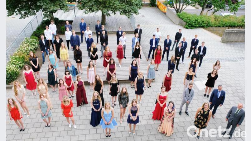 Improvisieren heißt es zu Coronazeiten. So zeigen sich die 72 Abiturienten und die Schulleitung vor der Aushändigung des Reifezeugnisses in ungewöhnlicher Formation. Bild: do