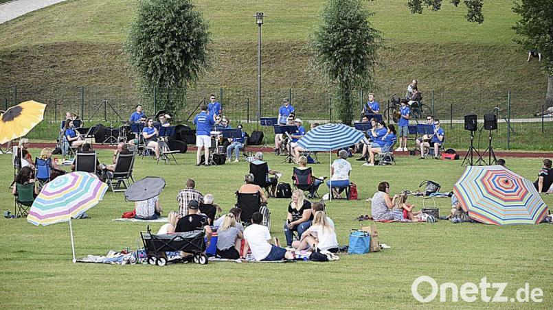 Den gebotenen Abstand wahren die Auerbacher, als sie es sich zum Blasmusik-Picknick auf dem Schulsportplatz gemütlich machen. Bild: sck