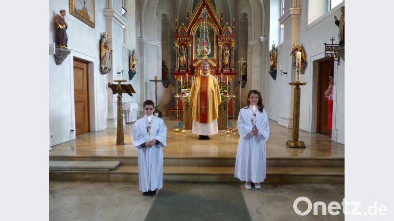 Leandro de Lazzer (links) mit Pfarrer Adam Nieciecki und Selina Högler (rechts) vor dem Altar -mit Abstand. Bild: sl