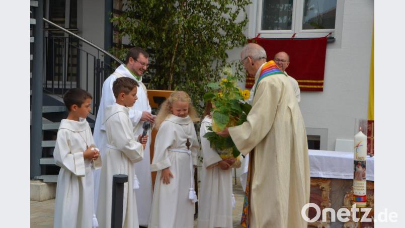 Kommunionkinder überbrachten Pfarrer Franz Winklmann Sonnenblumen und überraschten mit einem Gedicht. Bild: dob