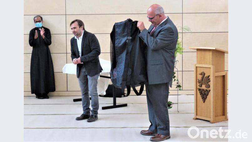 Architekt Florian Schabner (Mitte) überreichte an Bürgermeister Klaus Meyer einen Sack voller Turnbälle. Links im Bild Pfarrer George Parankimalil. Bild: ubb