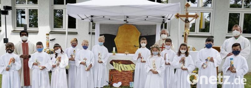Unter freiem Himmel im Schulgarten empfingen zwölf Mädchen und Buben der Pfarrei Stulln ihre erste heilige Kommunion. Die Messfeier zelebrierten die Pfarrer Heinrich Rosner (hinten links neben dem Kreuz) und Joseph Kokkoth (links) mit Unterstützung von Gemeindereferent Markus Seefeld (rechts). 

. Bild: ohr