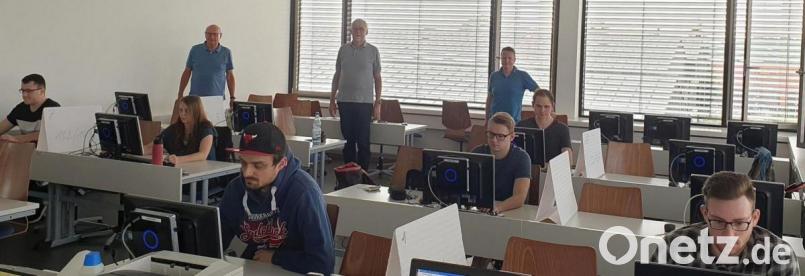 Konzentriert brüten die Prüflinge über den Fragen, die ihnen (hinten von links) Dr. Hermann Körner und die Programmierlehrer Stephan Rippert und Thilo Bareuther auf die Schultische gelegt haben. Bild: wro