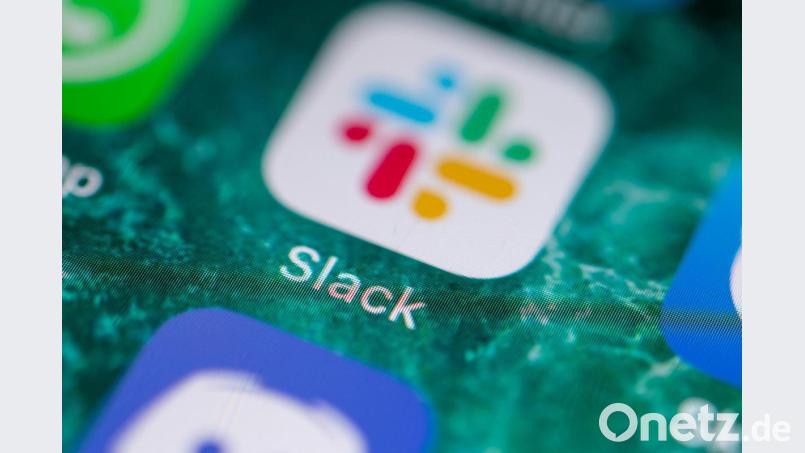 Der Bildschirm eines iPhones zeigt die Messenger-App Slack. Bild: Fabian Sommer/dpa