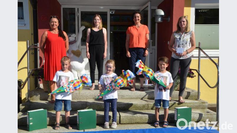 Mit der Schultüte in der Hand und der Sammelmappe, in der sämtliche kreativen Arbeiten der Kindergartenzeit festgehalten sind, wurden Benedikt Schatz, Anne Malzer und Tim Maier (vorne, von links nach rechts) von Leiterin Birgit Zant (links) und dem Team verabschiedet. Der &quot;Rauswurf&quot; wurde zu einem bewegenden Augenblick für Kinder, Erzieher aber auch Eltern. Bild: dob