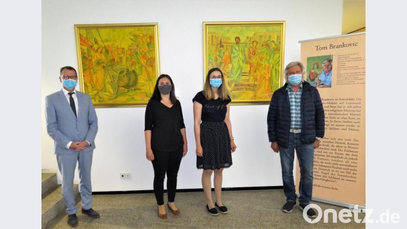 Nach der Corona-Zwangspause kann die Ausstellung „Jesu Botschaft“ von Tom Brankovic (rechts) in der Volksbank Raiffeisenbank-Filiale Tirschenreuth wieder besichtigt werden. Ohne Mundschutz geht es allerdings nicht, demonstrieren Regionalmarktleiter Helmut Wolfrum sowie Iris Franz und Vanessa Luber vom Service-Team (von links). Bild: ubb