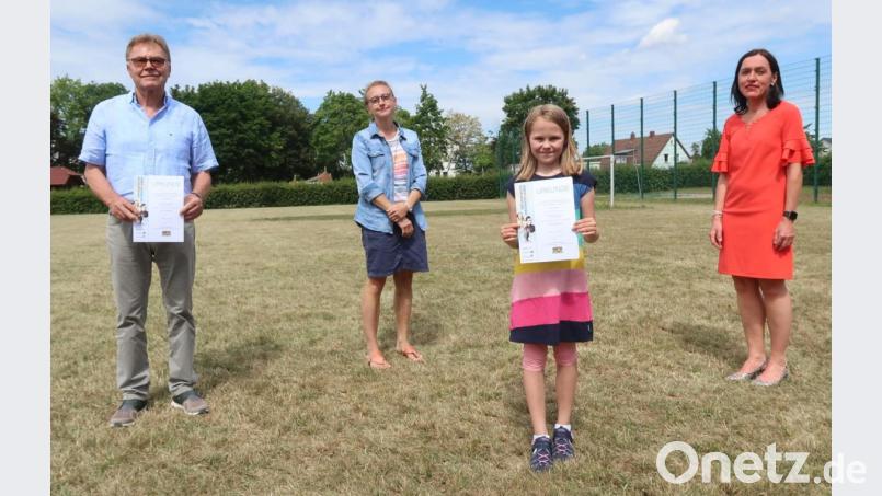 Franziska Peter freut sich über den dritten Preis des Landeswettbewerbs "Erinnerungszeichen" in der Kategorie Grundschule. Es gratulieren ihr (von links) Großvater Hermann Mertel, Klassleiterin Silke Sticht und Rektorin Tanja Willax-Nickl (rechts). Bild: Kunz